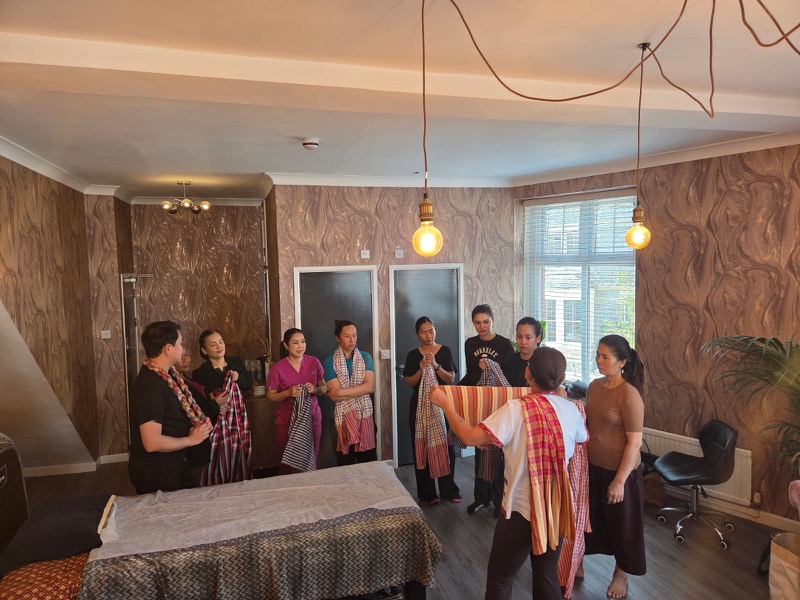 Students learning scarf massage techniques